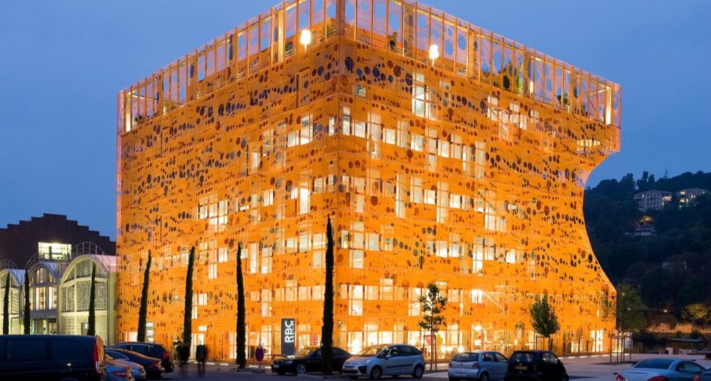 Le parcours professionnel de Jean-Christophe Larose Né à Lyon en 1967, Jean-Christophe Larose a suivi des études à l'IDRAC, école de commerce et de management, et à l'ISG, école de commerce de l'international. Passionné par l’architecture et l’urbanisme, il s’intéresse tout particulièrement à la gestion des PME, cycle dont il est diplômé. Il part trois ans au Portugal, entre 1989 et 1991, dans le cadre d’un volontariat au service national en entreprise, en tant que rattaché auprès de la BNP. Ce pays qui s’ouvre alors au marché le sensibilise aux problématiques immobilières, prenant notamment en compte les enjeux des entreprises qui souhaitent s’implanter dans les pays lusophones. En 1991, il intègre le groupe Auguste Thouard à Lyon. Deux ans plus tard, il lance avec deux associés sa propre entreprise de conseils aux sociétés dans leur recherche d'implantation, la société Cour Carrée. En 1997, celle-ci fusionne avec Adéquation, donnant naissance à Stratis Conseil, qui prend la place de leader dans le domaine des études de marché de l'immobilier. Le groupe Cardinal, fondé par Jean-Christophe Larose Néanmoins, Jean-Christophe Larose prend conscience de la nécessité de séparer deux activités bien distinctes, le conseil d’un côté et la promotion immobilière de l’autre. Ce second volet donnera naissance au Groupe Cardinal, qui est aujourd'hui devenu un des principaux promoteurs indépendants sur le plan national. Les premières réalisations voient le jour en 2004 : il s’agit alors du siège de Lyon Agglomération de la Compagnie Générale des Eaux et de l'opération de résidence de tourisme Park & Suite à La part-Dieu. Initialement installé à la Cité Internationale, le Groupe Cardinal et sa quarantaine de collaborateurs déménagent en mars 2010 dans le célèbre Cube Orange, réalisé par le cabinet d'architectes Jakob+MacFarlane, au centre du quartier lyonnais de Confluence Le Groupe a pour mission de proposer des solutions immobilières globales, qui vont du montage de l’opération au portage immobilier, en passant par la construction et la gestion, au travers de ses filiales Cardinal Promotion, Cardinal Campus et Foncière Cardinal. Sont concernés tant l’immobilier tertiaire que l’hôtellerie ou les logements gérés. L’entreprise de l’homme d’affaires a su se développer, se structurer et s’accroître grâce à la souplesse et la puissance dont il fait preuve ; son chiffre d’affaires annuel atteint aujourd'hui environ 100 millions d’Euros, avec plus de 100 collaborateurs. Les projets immobiliers de Jean-Christophe Larose Depuis la création du Groupe Cardinal, l’entrepreneur a collaboré avec de multiples jeunes urbanistes, mais aussi avec de grands noms de l’architecture internationale tels que Jakob+Macfarlane, Jean Nouvel, Rudy Ricciotti ou encore Jean-Michel Wilmotte. D’importants projets sont actuellement en cours un immeuble d’habitation conçu par l’architecte Jean Nouvel, qui sera érigé à Lyon Confluence, revêtu d’une double peau aux multiples vitrages, et prenant en compte les désirs des futurs habitants, tels que la proximité d’avec les services, les loisirs et les lieux d’activités Le groupe va également réaliser la nouvelle Polyclinique du Tondu à Bordeaux, un site pour l’entreprise internationale ABB et des hôtels à Lyon et Saint Ouen. Jean-CHRISTOPHE LAROSE et la COnfluence Interview à l'occasion des 10 ans des Docks de Lyon, Septembre 2018 Comment le groupe Cardinal est-il devenu le promoteur majeur des Docks ? Nous avons d’abord obtenu la réalisation du siège du Progrès, livré en 2007, puis nous avons répondu à une consultation, sur la réhabilitation du bâtiment des Douanes. A l’époque, peu de promoteurs semblaient intéressés par ce quartier déserté, malgré sa situation exceptionnelle entre les 2 fleuves, proche de l’hypercentre. Nous avons eu l’audace d’y croire. Ensuite la réalisation du Cube Orange et la réhabilitation des Salins nous ont permis de prouver notre capacité à gérer des dossiers complexes, d’installer notre siège à Confluence. Le succès du partenariat public/privé a naturellement motivé d’autres projets. Assez rapidement j’ai investi aussi dans les commerces des rez-de-chaussée du quartier, (Docks 40, Selcius, Pavillon 52…) : en contribuant à l’animation du quartier on dépasse notre rôle de promoteur, et on contribue à la pérennité de l’attractivité du quartier. Avez-vous pris un réel risque à l’époque ? Bien entendu, le métier de promoteur est émaillé de nombreux paris, sans prendre de risque nous n’entreprenons jamais. Il faut oser. Oui, j’ai pris des risques mais je savais, même si certaines nuits ont été courtes, que le défi allait être relevé. Et le jeu en valait la chandelle : Confluence est un véritable laboratoire d’architecture contemporaine, et un nouveau centre économique, avec sa mixité bureaux/commerces/logements. Les Docks ont apporté un caractère novateur et ambitieux à la Métropole. Et c’est cette audace qui lui donne aujourd’hui sa dimension européenne. Prendre un bateau à Lyon c’est spectaculaire, en 20 minutes on voit 20 siècles d’histoire se répondre ! Les bâtiments réalisés sur les Docks ont-ils contribué à accélérer la croissance de votre groupe ? C’est évident. Le Cube Orange de Jakob-MacFarlane est devenu rapidement le symbole du quartier, des centaines d’articles de presse du monde entier l’ont montré, et l’image de Cardinal y est désormais intimement liée. D’autres réalisations comme le Pavillon 52 imaginé par Rudy Ricciotti, font aussi partie des œuvres majeures des Docks. Cette image nous a ouvert des portes : aujourd’hui le Groupe Cardinal développe plus de 60% de son activité en dehors de la région. A Bordeaux par exemple nous sommes un des acteurs majeurs du développement de Brazza, grâce à notre expérience des programmes mixtes sur des quartiers en devenir. Expérience qui nous emmène aussi construire des projets de logements, bureaux, résidences étudiantes, commerces dans des secteurs en mutation telles qu’aux portes des Puces de Saint Ouen, ou à Grand Arenas, aménagement de l’Ecovallée de Nice. Le quai Rambaud est la meilleure vitrine du Groupe, la preuve de notre capacité à mener à bien des projets d’envergure - comme avec Euronews lorsqu’il a fallu intégrer un process industriel à une œuvre d’art – avec le souci d’une forte identité architecturale. Et à l’entrée des Docks, en 2019 sera livré Ycone : même Jean Nouvel a été sensible à l’attrait de Confluence ! Le parcours professionnel de Jean-Christophe Larose Né à Lyon en 1967, Jean-Christophe Larose a suivi des études à l'IDRAC, école de commerce et de management, et à l'ISG, école de commerce de l'international. Passionné par l’architecture et l’urbanisme, il s’intéresse tout particulièrement à la gestion des PME, cycle dont il est diplômé. Il part trois ans au Portugal, entre 1989 et 1991, dans le cadre d’un volontariat au service national en entreprise, en tant que rattaché auprès de la BNP. Ce pays qui s’ouvre alors au marché le sensibilise aux problématiques immobilières, prenant notamment en compte les enjeux des entreprises qui souhaitent s’implanter dans les pays lusophones. En 1991, il intègre le groupe Auguste Thouard à Lyon. Deux ans plus tard, il lance avec deux associés sa propre entreprise de conseils aux sociétés dans leur recherche d'implantation, la société Cour Carrée. En 1997, celle-ci fusionne avec Adéquation, donnant naissance à Stratis Conseil, qui prend la place de leader dans le domaine des études de marché de l'immobilier. Le groupe Cardinal, fondé par Jean-Christophe Larose Néanmoins, Jean-Christophe Larose prend conscience de la nécessité de séparer deux activités bien distinctes, le conseil d’un côté et la promotion immobilière de l’autre. Ce second volet donnera naissance au Groupe Cardinal, qui est aujourd'hui devenu un des principaux promoteurs indépendants sur le plan national. Les premières réalisations voient le jour en 2004 : il s’agit alors du siège de Lyon Agglomération de la Compagnie Générale des Eaux et de l'opération de résidence de tourisme Park & Suite à La part-Dieu. Initialement installé à la Cité Internationale, le Groupe Cardinal et sa quarantaine de collaborateurs déménagent en mars 2010 dans le célèbre Cube Orange, réalisé par le cabinet d'architectes Jakob+MacFarlane, au centre du quartier lyonnais de Confluence Le Groupe a pour mission de proposer des solutions immobilières globales, qui vont du montage de l’opération au portage immobilier, en passant par la construction et la gestion, au travers de ses filiales Cardinal Promotion, Cardinal Campus et Foncière Cardinal. Sont concernés tant l’immobilier tertiaire que l’hôtellerie ou les logements gérés. L’entreprise de l’homme d’affaires a su se développer, se structurer et s’accroître grâce à la souplesse et la puissance dont il fait preuve ; son chiffre d’affaires annuel atteint aujourd'hui environ 100 millions d’Euros, avec plus de 100 collaborateurs. Les projets immobiliers de Jean-Christophe Larose Depuis la création du Groupe Cardinal, l’entrepreneur a collaboré avec de multiples jeunes urbanistes, mais aussi avec de grands noms de l’architecture internationale tels que Jakob+Macfarlane, Jean Nouvel, Rudy Ricciotti ou encore Jean-Michel Wilmotte. D’importants projets sont actuellement en cours un immeuble d’habitation conçu par l’architecte Jean Nouvel, qui sera érigé à Lyon Confluence, revêtu d’une double peau aux multiples vitrages, et prenant en compte les désirs des futurs habitants, tels que la proximité d’avec les services, les loisirs et les lieux d’activités Le groupe va également réaliser la nouvelle Polyclinique du Tondu à Bordeaux, un site pour l’entreprise internationale ABB et des hôtels à Lyon et Saint Ouen. Jean-CHRISTOPHE LAROSE et la COnfluence Interview à l'occasion des 10 ans des Docks de Lyon, Septembre 2018 Comment le groupe Cardinal est-il devenu le promoteur majeur des Docks ? Nous avons d’abord obtenu la réalisation du siège du Progrès, livré en 2007, puis nous avons répondu à une consultation, sur la réhabilitation du bâtiment des Douanes. A l’époque, peu de promoteurs semblaient intéressés par ce quartier déserté, malgré sa situation exceptionnelle entre les 2 fleuves, proche de l’hypercentre. Nous avons eu l’audace d’y croire. Ensuite la réalisation du Cube Orange et la réhabilitation des Salins nous ont permis de prouver notre capacité à gérer des dossiers complexes, d’installer notre siège à Confluence. Le succès du partenariat public/privé a naturellement motivé d’autres projets. Assez rapidement j’ai investi aussi dans les commerces des rez-de-chaussée du quartier, (Docks 40, Selcius, Pavillon 52…) : en contribuant à l’animation du quartier on dépasse notre rôle de promoteur, et on contribue à la pérennité de l’attractivité du quartier. Avez-vous pris un réel risque à l’époque ? Bien entendu, le métier de promoteur est émaillé de nombreux paris, sans prendre de risque nous n’entreprenons jamais. Il faut oser. Oui, j’ai pris des risques mais je savais, même si certaines nuits ont été courtes, que le défi allait être relevé. Et le jeu en valait la chandelle : Confluence est un véritable laboratoire d’architecture contemporaine, et un nouveau centre économique, avec sa mixité bureaux/commerces/logements. Les Docks ont apporté un caractère novateur et ambitieux à la Métropole. Et c’est cette audace qui lui donne aujourd’hui sa dimension européenne. Prendre un bateau à Lyon c’est spectaculaire, en 20 minutes on voit 20 siècles d’histoire se répondre ! Les bâtiments réalisés sur les Docks ont-ils contribué à accélérer la croissance de votre groupe ? C’est évident. Le Cube Orange de Jakob-MacFarlane est devenu rapidement le symbole du quartier, des centaines d’articles de presse du monde entier l’ont montré, et l’image de Cardinal y est désormais intimement liée. D’autres réalisations comme le Pavillon 52 imaginé par Rudy Ricciotti, font aussi partie des œuvres majeures des Docks. Cette image nous a ouvert des portes : aujourd’hui le Groupe Cardinal développe plus de 60% de son activité en dehors de la région. A Bordeaux par exemple nous sommes un des acteurs majeurs du développement de Brazza, grâce à notre expérience des programmes mixtes sur des quartiers en devenir. Expérience qui nous emmène aussi construire des projets de logements, bureaux, résidences étudiantes, commerces dans des secteurs en mutation telles qu’aux portes des Puces de Saint Ouen, ou à Grand Arenas, aménagement de l’Ecovallée de Nice. Le quai Rambaud est la meilleure vitrine du Groupe, la preuve de notre capacité à mener à bien des projets d’envergure - comme avec Euronews lorsqu’il a fallu intégrer un process industriel à une œuvre d’art – avec le souci d’une forte identité architecturale. Et à l’entrée des Docks, en 2019 sera livré Ycone : même Jean Nouvel a été sensible à l’attrait de Confluence !